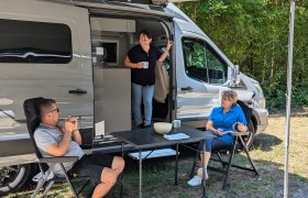 Drei Personen entspannen vor einem Wohnmobil im Schatten., © Donau Niederösterreich, Wagner