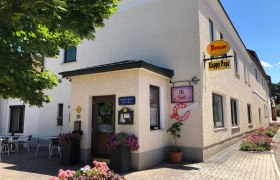 Eckgebäude mit Café 'Happy Pepi', Außensitzbereich und Blumenschmuck., © © Donau Niederösterreich