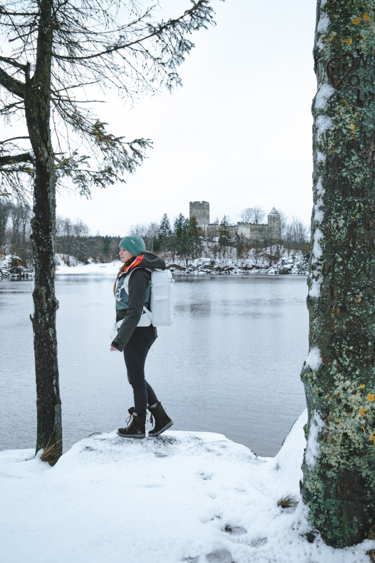 Frau steht vor einem See, schneebedeckte Landschaft