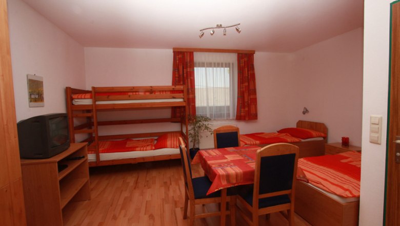 Gemütliches Gästezimmer mit Etagenbett, Einzelbetten und Tisch., © Gasthof Hödl