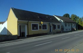 Gelbes Gebäude an einer Straße mit blauem Himmel im Hintergrund., © Familie Kramreiter