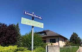 Straßenschild 'Kriemhildstraße' vor einem Wohnhaus und blauen Himmel., © Donau Niederösterreich