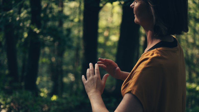 Frau steht im Wald