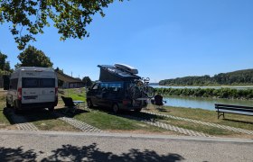 Wohnmobile am Flussufer mit Fahrrädern und Campingstühlen., © Donau Niederösterreich, Wagner