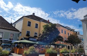 Bunte Häuser und Straßencafé in einer sonnigen Stadtstraße., © Donau Niederösterreich Ketting