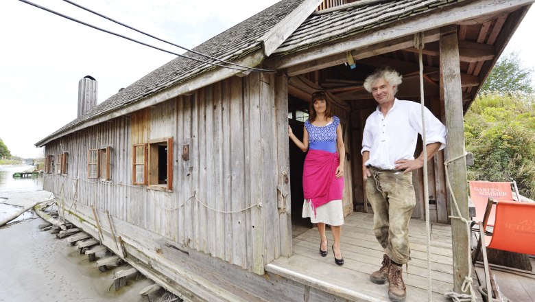 Zwei Personen vor einer rustikalen Holzhütte am Flussufer., © Donau Niederösterreich, Steve Haider