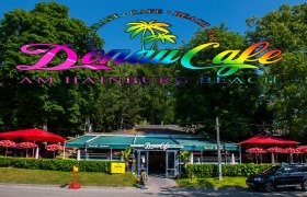 DonauCafe am Hainburg Beach mit buntem Logo und roten Sonnenschirmen., © Donau Cafe Hainburg