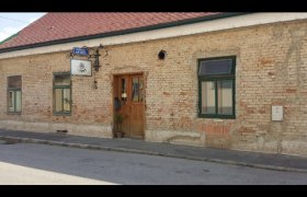 Altes Backsteingebäude mit Holztür und Schild in einer ruhigen Straße., © Donau Niederösterreich