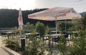 Terrasse mit Tischen, Stühlen und Sonnenschirmen, umgeben von Natur., © Donau NÖ Tourismus GmbH