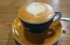 Cappuccino mit Herz-Latte-Art in blauer Tasse auf Holztisch., © Donau Niederösterreich